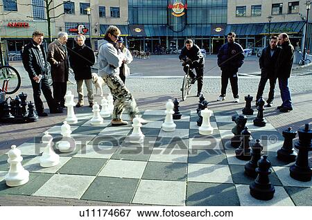 chess game, Amsterdam, The Netherlands, Holland, Europe, Men play a chess match outside on a giant chess board in front of the Hard Rock CafT in the city of Amsterdam. View Large Photo Image Stock Photo - chess game, Amsterdam, The Netherlands, Holland, Europe, Men play a chess match outside on a giant chess board in front of the Hard Rock CafT in the city of Amsterdam.. Fotosearch