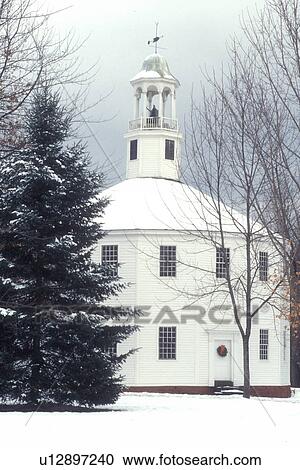 Stock Image -  church, chapel, winter, snow, Vermont, The Old Round Church (a 16-sided polygon) National Historical Landmark on a snow covered day in Richmond in Chittenden County in the state of Vermont. . Fotosearch