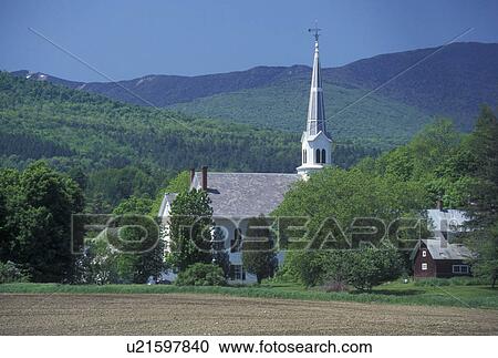 Stock Image -  church, spring, Waitsfield, VT, Vermont, Scenic view of the United Church of Christ in the village of Waitsfield in the Mad River Valley in the spring. The Green Mountains with Sugarbush Ski Area are in the background.. Fotosearch