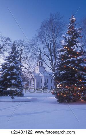 Stock Image -  church, village, chapel, town, winter scene, outdoor, decorations, holiday, snow, Vermont, Picturesque view of The First Baptist Church of Bristol and a large evergreen tree on the Green decorated with colorful lights for the Christmas holiday season on . Fotosearch