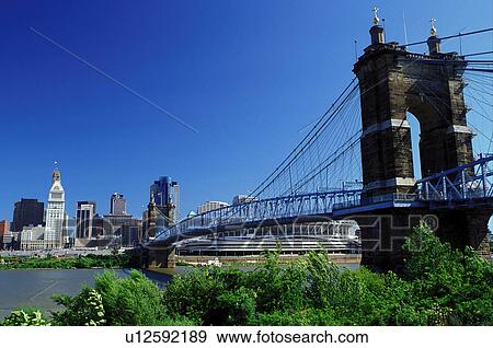 Stock Photo -  Cincinnati, skyline, bridge, OH, Ohio, Downtown skyline of Cincinnati and the John A. Roebling Suspension Bridge crossing the Ohio River.. Fotosearch