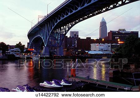 Stock Image -  Cleveland, OH, Ohio, bridge, Flats District, Main Avenue Bridge crosses the Cuyahoga River in the Flats District of downtown Cleveland in the evening.. Fotosearch