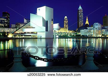 Stock Photography -  Cleveland, skyline, OH, Ohio, Skyline of downtown Cleveland and the Rock and Roll Hall of Fame and Museum along the waterfront of North Coast Harbor in the evening.. Fotosearch