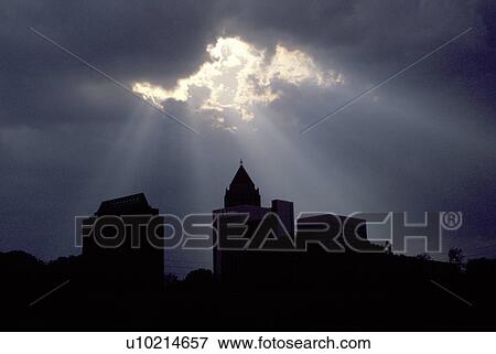 Stock Photo -  clouds, sun ray, Georgia, GA, Atlanta, Sun rays break through the clouds after a rain storm above the silhouette of the IBM Tower in downtown Atlanta.. Fotosearch