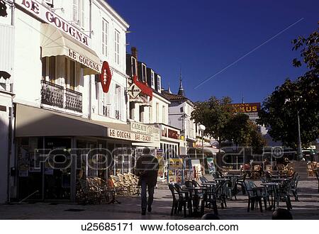 Stock Image -  Cognac, outdoor cafT, France, Poitou-Charentes, Charente, Europe, Outdoor cafT and shops in the downtown of Cognac famous for the production of double-distilled spirits.. Fotosearch