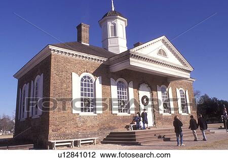 Stock Image -  Colonial Williamsburg, Virginia, VA, Williamsburg, People stand outside the Courthouse talking to interpreters in colonial costumes in Colonial Williamsburg.. Fotosearch