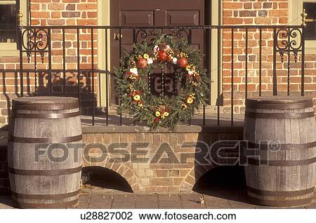 Stock Image -  Colonial Williamsburg, Virginia, VA, Williamsburg, A wreath made of greens and fruit decorates the iron railing of the village store for Christmas in Colonial Williamsburg.. Fotosearch