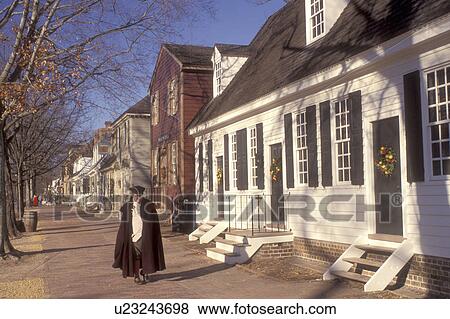 Colonial Williamsburg, Virginia, VA, Williamsburg, A man interpreter wearing a colonial costume walks down the sidewalk outside the village stores in Colonial Williamsburg. View Large Photo Image Stock Photo - Colonial Williamsburg, Virginia, VA, Williamsburg, A man interpreter wearing a colonial costume walks down the sidewalk outside the village stores in Colonial Williamsburg.. Fotosearch