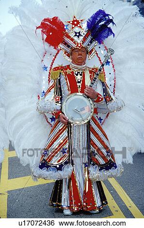 Stock Photograph -  costume, parade, banjo, Philadelphia, PA, Pennsylvania, A member of a String Band dressed in an ornate patriotic costume holds his banjo in the Mummers Day Parade on New Years Day in Philadelphia.. Fotosearch