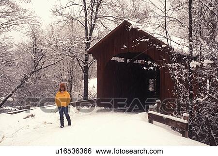 covered bridge, winter, Northfield Falls, Vermont, VT, Woman walking on a snow covered country road near Slaughter House Covered Bridge on a snowy day in Northfield Falls in winter. View Large Photo Image Stock Photograph - covered bridge, winter, Northfield Falls, Vermont, VT, Woman walking on a snow covered country road near Slaughter House Covered Bridge on a snowy day in Northfield Falls in winter.. Fotosearch