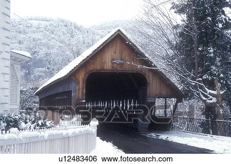 Stock Photograph -  covered bridge, winter, Woodstock, snow, The scenic Middle Covered Bridge on a wintry day in the snow in Woodstock in Windsor County in the state of Vermont. . Fotosearch
