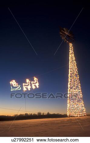 decorations, outdoor, Christmas, holiday, snow, winter, An illuminated Santa's sleigh pulled by reindeer flies through the air towards tall illuminated Christmas tree in East Montpelier at night in Washington County in the state of Vermont. View Large Photo Image Stock Image - decorations, outdoor, Christmas, holiday, snow, winter, An illuminated Santa's sleigh pulled by reindeer flies through the air towards tall illuminated Christmas tree in East Montpelier at night in Washington County in the state of Vermont. . Fotosearch