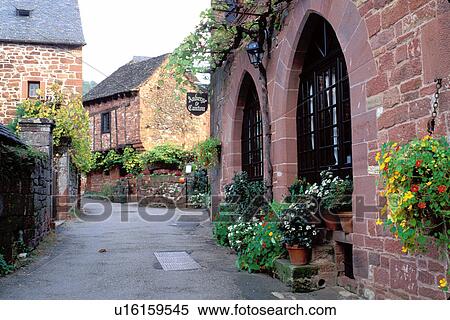 Stock Photography -  Dordogne, Perigord, France, Limousin, Correze, Collonges-la-Rouge, Europe, A narrow street runs through the medieval village of Collonges-la-Rouge made entirely of red sandstone. . Fotosearch