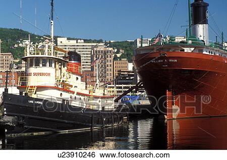 Stock Photograph -  Duluth, MN, Minnesota, Tugboat and the William A. Irwin Ore Boat moored at the dock in Duluth Harbor on Lake Superior in Duluth.. Fotosearch