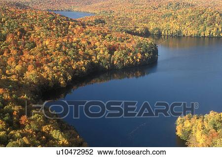 Stock Image -  fall, aerial, lake, Woodbury, VT, Vermont, Scenic aerial view from Nichols Ledge of the colorful fall foliage surrounding Nichols Pond in the autumn.. Fotosearch