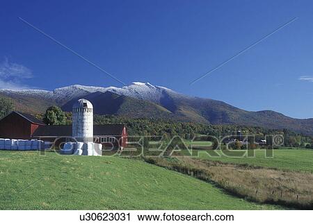 Stock Image -  farm, Cambridge, VT, Vermont, Mount Mansfield, Scenic view of farm with red barn in Pleasant Valley in the fall with the first snow on Mt. Mansfield in the background.. Fotosearch