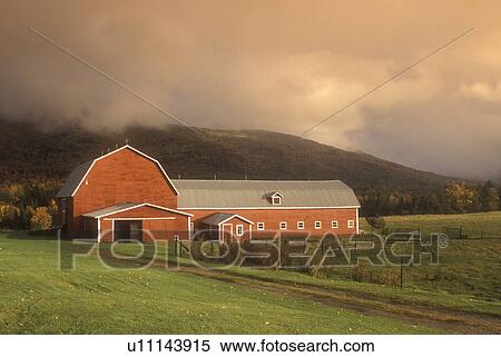 Stock Photography -  fog, barn, Waterbury, VT, Vermont, Fog rolls over the mountain behind a red barn on a farm in autumn. . Fotosearch