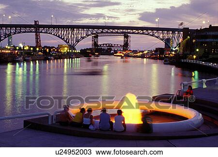 fountain, Cleveland, OH, Ohio, Flats District, Fountain at Settlers Landing Park along the Cuyahoga River in the Flats District of downtown Cleveland illuminated at night. Main Avenue Bridge crossing the Cuyahoga River in the background View Large Photo Image Stock Image - fountain, Cleveland, OH, Ohio, Flats District, Fountain at Settlers Landing Park along the Cuyahoga River in the Flats District of downtown Cleveland illuminated at night. Main Avenue Bridge crossing the Cuyahoga River in the background . Fotosearch