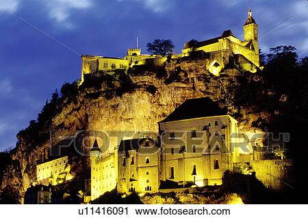Stock Image -  France, Dordogne, Perigord, Rocamadour, Midi-Pyrenees, Lot, Europe, The fortified pilgrimage town of Rocamadour situated on the terraced limestone cliffs is illuminated at night. . Fotosearch