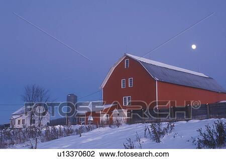 Stock Image -  full moon, red barn, Vermont, VT, Full moon over red barn and white farmhouse in the evening in Albany in the winter.. Fotosearch