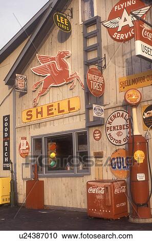 Stock Image -  gas station, antique, collectibles, A collection of old signs and other memorabilia on Steve Morris Garage and Auto Sales in Orange in Orange County in the state of Vermont.. Fotosearch