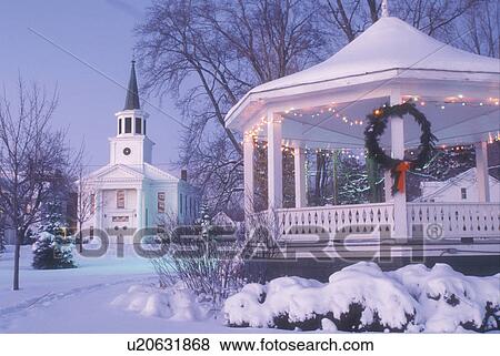 Stock Photo -  gazebo, church, Christmas, chapel, decorations, winter scene, holiday, village, snow, Vermont, The First Baptist Church and Gazebo on the Green are decorated for the Christmas holiday season on a snow covered evening in the town of Bristol in Addison Cou. Fotosearch