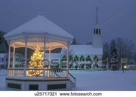 Stock Image -  gazebo, winter scene, village, church, snow, Vermont, A Christmas tree with white lights decorates the gazebo on the Green with the picturesque Townshend Church in the background on a snow covered night in the village of Townshend in Windham County in th. Fotosearch
