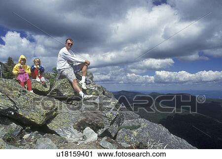 Stock Image -  hiking, Long Trail, Vermont, VT, Father and daughters sit on the summit of Mt. Mansfield in Stowe.. Fotosearch