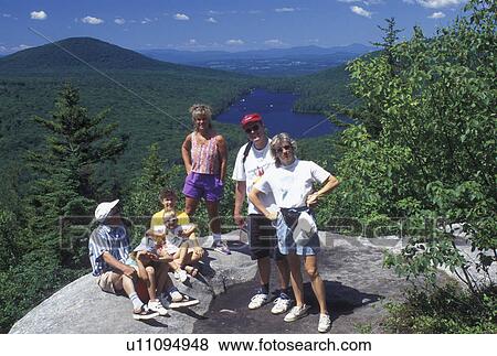 Stock Photo -  hiking, spring, Groton State Forest, VT, Vermont, Family poses for picture on top of Owl's Head overlooking Kettle Pond in Groton State Forest in the spring.. Fotosearch