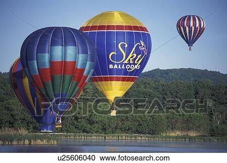 Stock Image -  hot air balloon, Vermont, VT, Quechee, Hot air balloons hover above the calm water at the Quechee Hot Air Balloon Festival.. Fotosearch