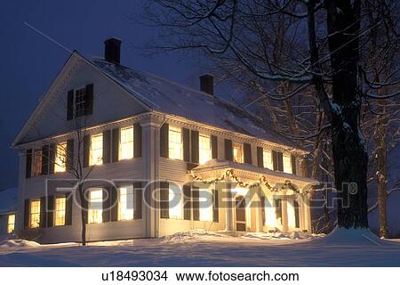 Picture -  house, Christmas, decorations, snow, winter, The windows of a house are illuminated at night for the Christmas holiday season in Townshend in Windham County in the state of Vermont. . Fotosearch