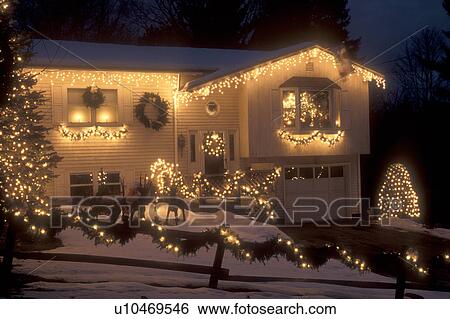 Stock Photograph -  house, home, Christmas, decorations, lights, snow, winter, A house is elegantly trimmed with tiny white lights for the Christmas holiday season in Montpelier at night in Washington County in the state of Vermont. . Fotosearch