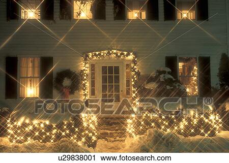 Stock Image -  house, home, holiday, Christmas, decorations, lights, snow, winter, A historic house in downtown Woodstock is beautifully decorated with white starlights for the Christmas holiday season at night in Windsor County in the state of Vermont. . Fotosearch