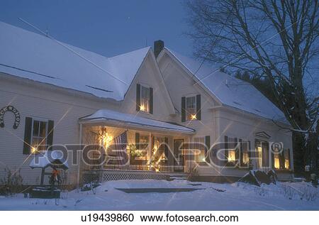 House Home Outdoor Christmas Holiday Decorations Snow Winter Yellow Candles Glow In The Windows Of An Old Farmhouse In East Calais On A Snow Covered Night In Washington County In The State