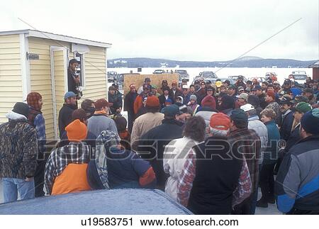 Stock Image -  ice fishing, fishing contest, winter, Greensboro, VT, Vermont, People gather around for the ice fishing award ceremony on Caspian Lake in winter. . Fotosearch
