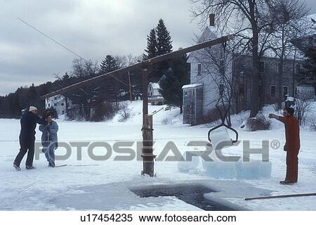 Stock Photography -  ice harvest, frozen lake, winter, Brookfield, VT, Vermont, Picking up a block of ice at the ice cutting contest at the Ice Harvest Festival on the frozen Sunset Lake in Brookfield in winter.. Fotosearch