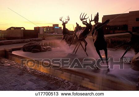 Stock Image -  Indianapolis, IN, Indiana, Deer fountain is displayed in front of the Eiteljorg Museum of American Indians and Western Art is housed in an adobe building at White River State Park.. Fotosearch