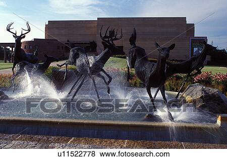 Stock Photo -  Indianapolis, IN, Indiana, Deer fountain is displayed in front of the Eiteljorg Museum of American Indians and Western Art is housed in an adobe building at White River State Park.. Fotosearch