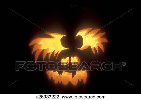 Stock Image -  Jack-O-Lantern, Halloween, close up, pumpkin, display, autumn, fall decoration, A close-up of a spooky glowing jack-o-lantern decorated at night for Halloween at Settlement Farm Pumpkin Show in Middlesex in Washington County in the state of Vermont. . Fotosearch