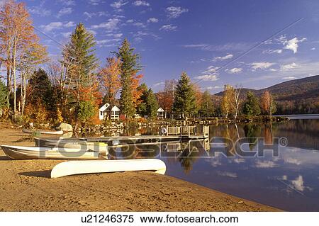 Stock Photography -  lake, Adirondacks, New York, Blue Mountain Lake, NY, A canoe and two rowboats on a quiet beach on the calm waters of Blue Mountain Lake in the autumn in the Adirondacks.. Fotosearch