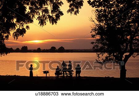 Stock Image -  Lewis & Clark Trail, MO, Missouri, People fishing along the Missouri River at sunset at Lewis & Clark State Park. Fotosearch