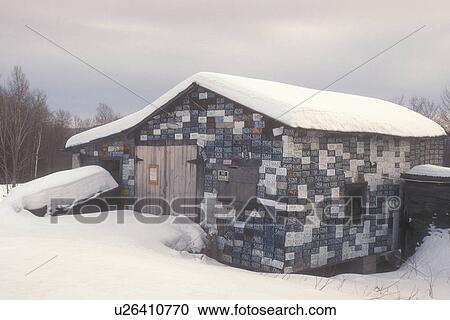 Stock Image -  license plates, barn, Vermont, VT, Old Vermont license plates covers a cabin in Granby in the winter.. Fotosearch
