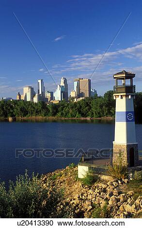 Stock Image -  lighthouse, skyline, Minneapolis, MN, Minnesota, Twin Cities, Lighthouse at Boom Island Park along the Mississippi River. Downtown skyline in the background.. Fotosearch