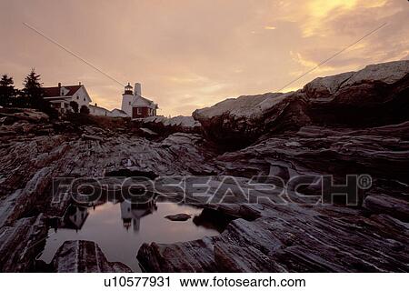 Stock Image -  lighthouse, sunrise, sunset, Maine, ME, Pemaquid Point, Bristol, Pemaquid Head Light reflects in a pool of water at sunrise along the rocky coast of the Atlantic Ocean.. Fotosearch