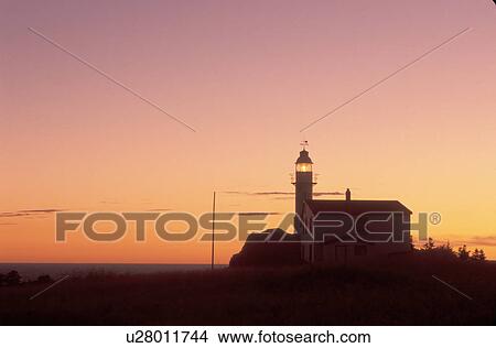 Picture -  lighthouse, sunrise, sunset, Newfoundland, NF, Canada, Lobster Cove Head Lighthouse on the Gulf of St. Lawrence at sunset. Gros Morne National Park.. Fotosearch