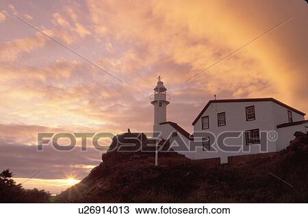 Stock Image -  lighthouse, sunrise, sunset, Newfoundland, NF, Canada, Lobster Cove Head Lighthouse on the Gulf of St. Lawrence at sunset. Gros Morne National Park.. Fotosearch