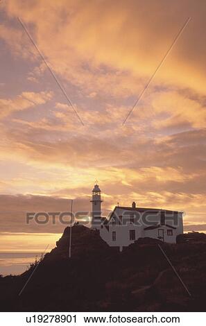 Stock Image -  lighthouse, sunset, sunrise, Newfoundland, NF, Canada, Lobster Cove Head Lighthouse on the Gulf of St. Lawrence at sunset. Gros Morne National Park.. Fotosearch