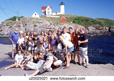 Stock Image -  lighthouse, York, Maine, ME, York Harbor, Cape Neddick Light, Nubble Lighthouse, on the rocky coast on the Atlantic Ocean. Group of students pose for picture in front of Nubble Lighthouse.. Fotosearch