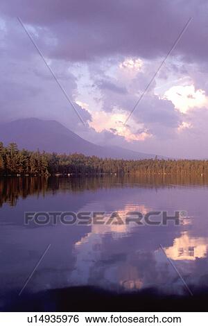 Stock Photograph -  Maine, Baxter Park, ME, Mt. Katahdin reflects in the calm waters of Daicey Pond at sunset in Baxter State Park.. Fotosearch