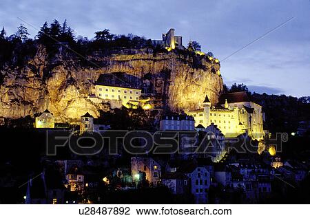 Stock Image -  medieval village, Rocamadour, Perigord, Dordogne, France, Midi-Pyrenees, Lot, Europe, The fortified pilgrimage town of Rocamadour which cascades down the terraced limestone cliffs is illuminated at night. . Fotosearch